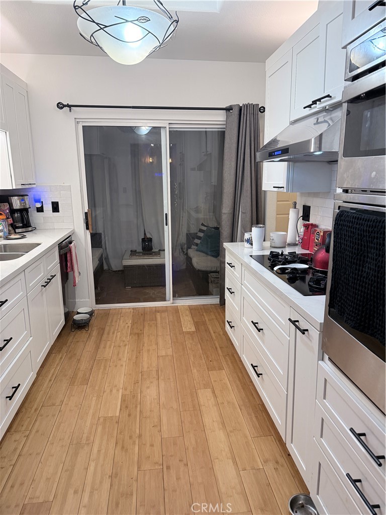 10626 Valley Spring Lane, Unit 103 Toluca Lake, CA 91602 - Photo 2 of 13 a kitchen with stainless steel appliances a refrigerator sink and white cabinets