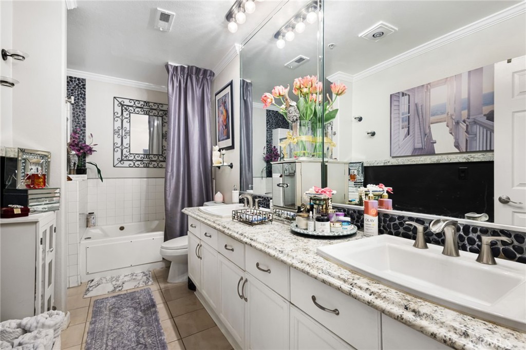 10626 Valley Spring Lane, Unit 103 Toluca Lake, CA 91602 - Photo 28 of 44 a bathroom with double vanity sinks a large mirror and a shower
