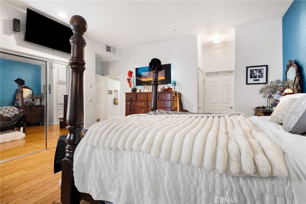 10626 Valley Spring Lane, Unit 103 Toluca Lake, CA 91602 - Photo 33 of 67 a bedroom with a bed and wooden floor