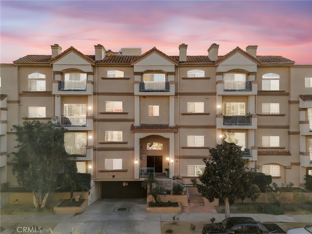 10626 Valley Spring Lane, Unit 103 Toluca Lake, CA 91602 - Photo 36 of 44 a front view of a residential apartment building with a yard