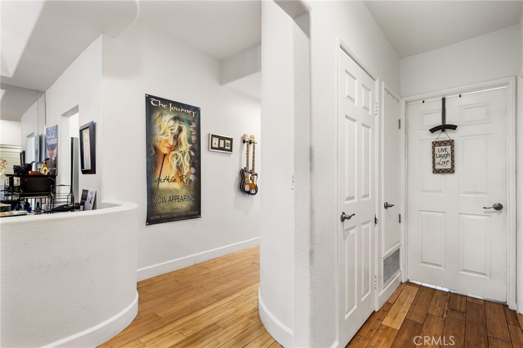 10626 Valley Spring Lane, Unit 103 Toluca Lake, CA 91602 - Photo 5 of 67 a view of a hallway with bathroom and wooden floor