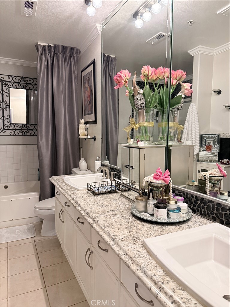 10626 Valley Spring Lane, Unit 103 Toluca Lake, CA 91602 - Photo 6 of 13 a bathroom with a granite countertop sink a large mirror and a shower