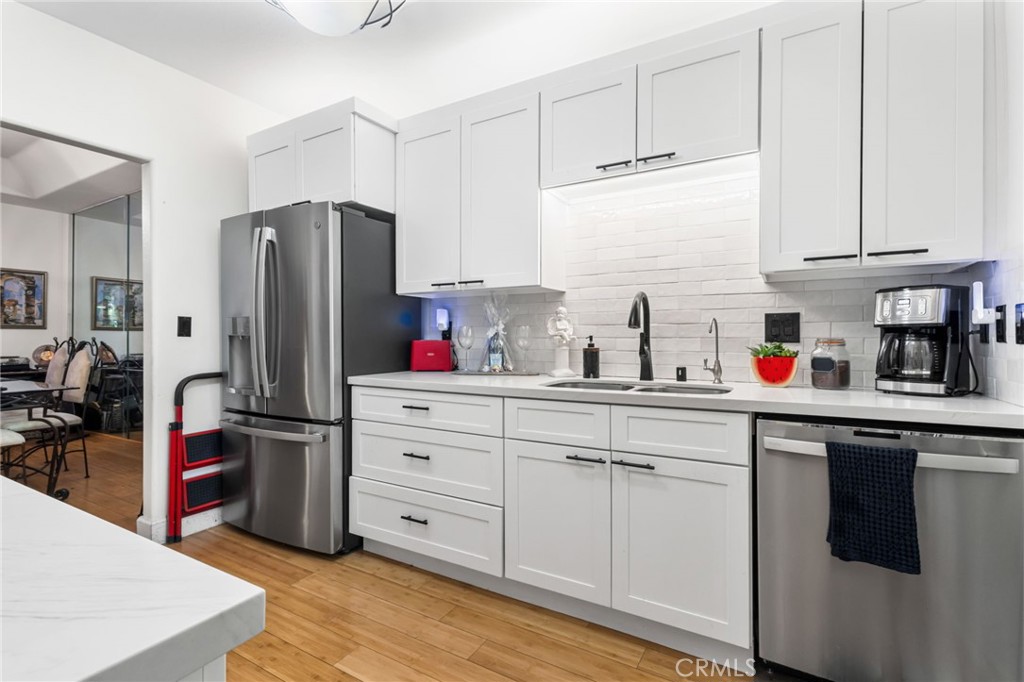 10626 Valley Spring Lane, Unit 103 Toluca Lake, CA 91602 - Photo 8 of 44 a kitchen with stainless steel appliances white cabinets and a refrigerator