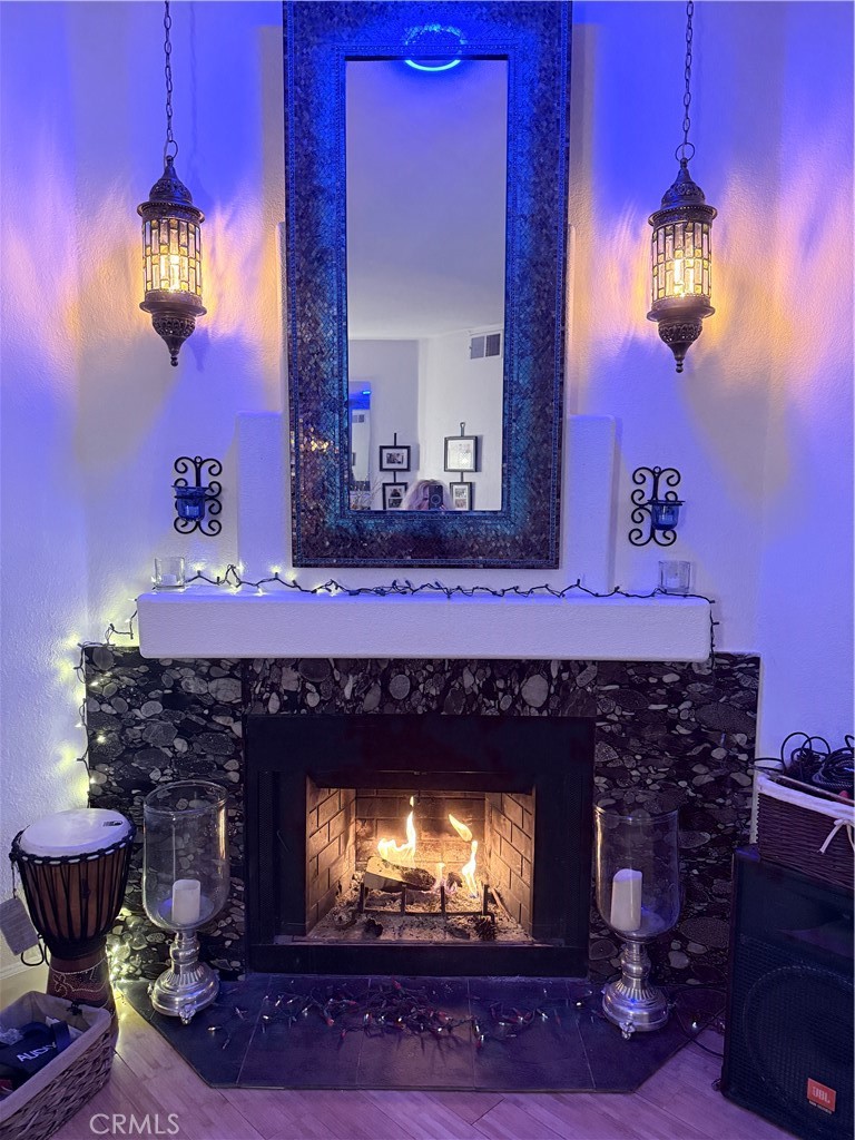 10626 Valley Spring Lane, Unit 103 Toluca Lake, CA 91602 - Photo 9 of 13 a fireplace with a clock on wall and a mirror