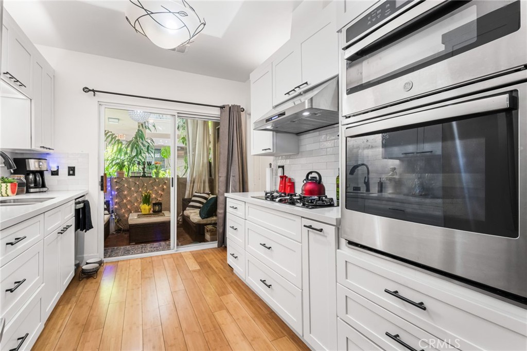 10626 Valley Spring Lane, Unit 103 Toluca Lake, CA 91602 - Photo 9 of 67 a kitchen that has a lot of cabinets and wooden floor