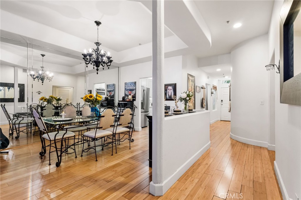 10626 Valley Spring Lane, Unit 103 Toluca Lake, CA 91602 - Photo 9 of 44 a view of a dining room and livingroom with furniture wooden floor a chandelier