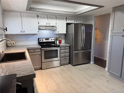 a kitchen with a sink stainless steel appliances and cabinets