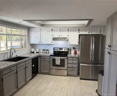 a kitchen with a refrigerator sink and cabinets