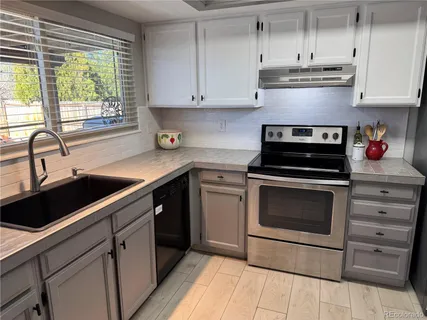 a kitchen with cabinets appliances and a sink