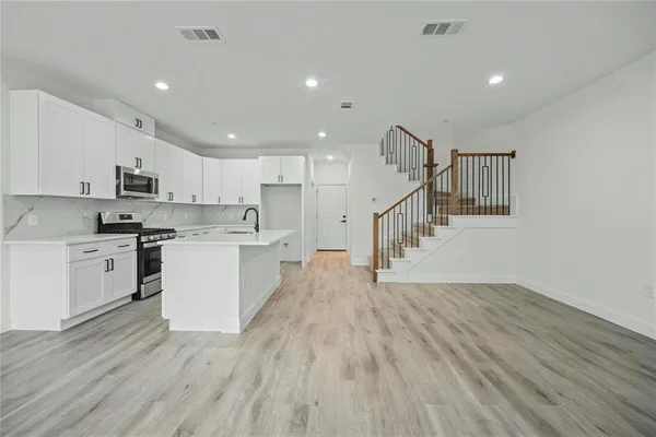 a view of kitchen with wooden floor and electronic appliances