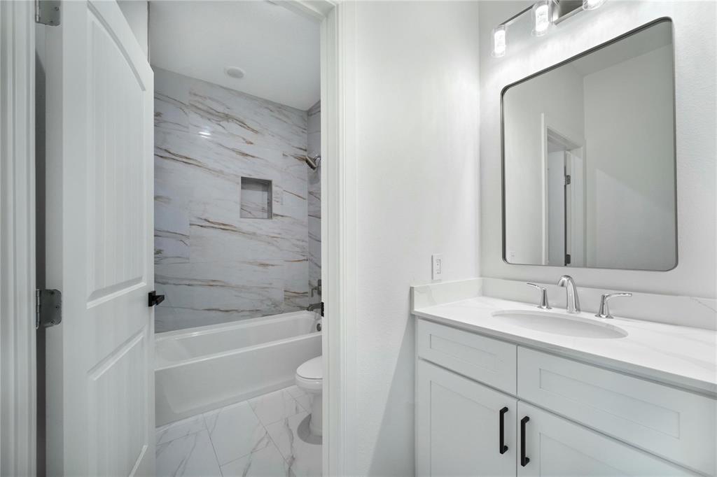6238 Dewitt Street Sachse, TX 75048 - Photo 16 of 21 a bathroom with a bathtub shower sink vanity and mirror