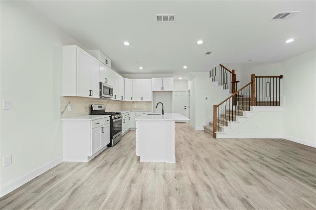6238 Dewitt Street Sachse, TX 75048 - Photo 20 of 21 a kitchen with a white cabinets and wooden floor