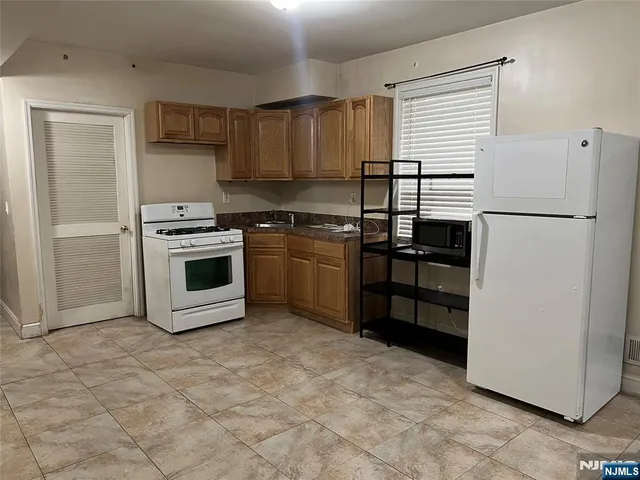 a kitchen with granite countertop a refrigerator stove and microwave