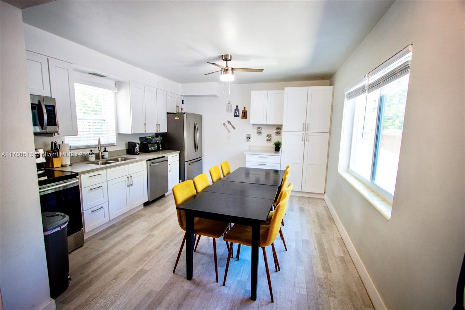 3981 Southwest 58th Street Dania Beach, FL 33312 - Photo 8 of 37 a kitchen with a table chairs refrigerator and microwave