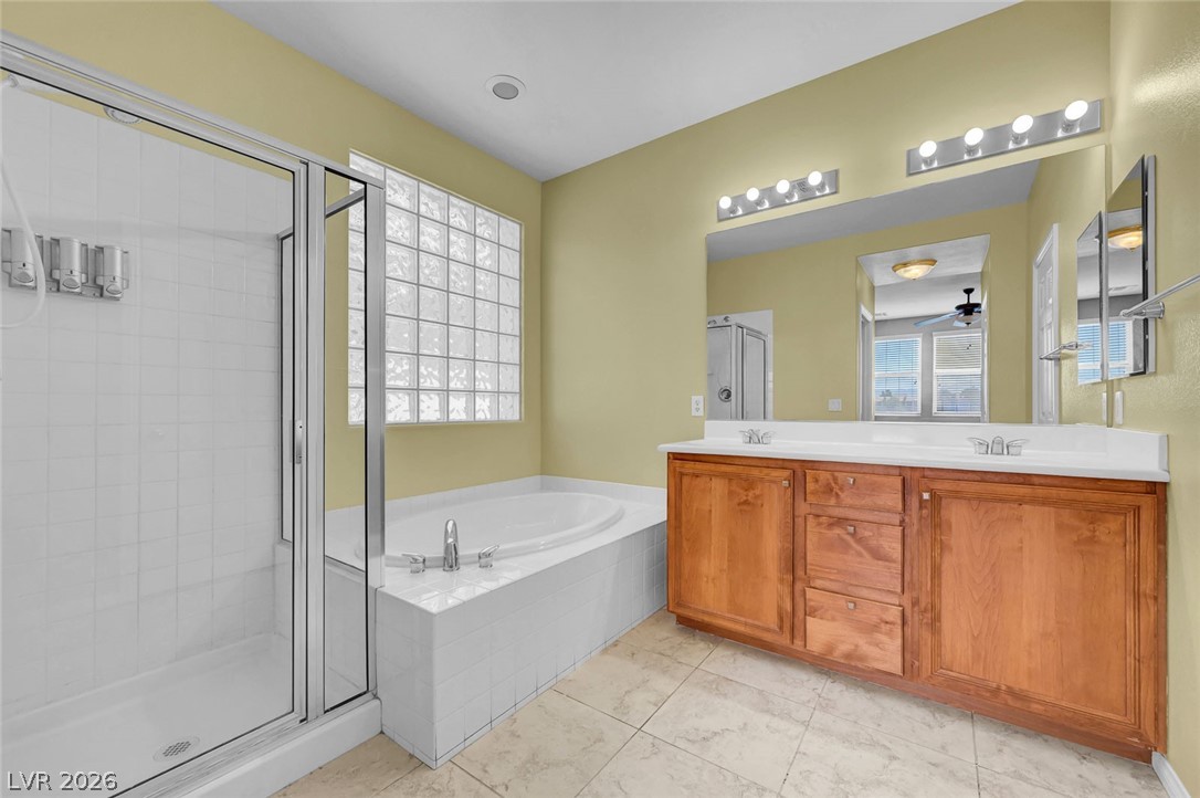 977 Sparkling Light Street Henderson, NV 89052 - Photo 46 of 75 This primary bathroom features a double vanity, a soaking tub, and a separate shower.