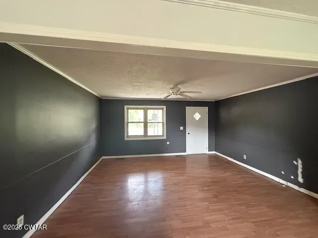en empty room with window and wooden floor