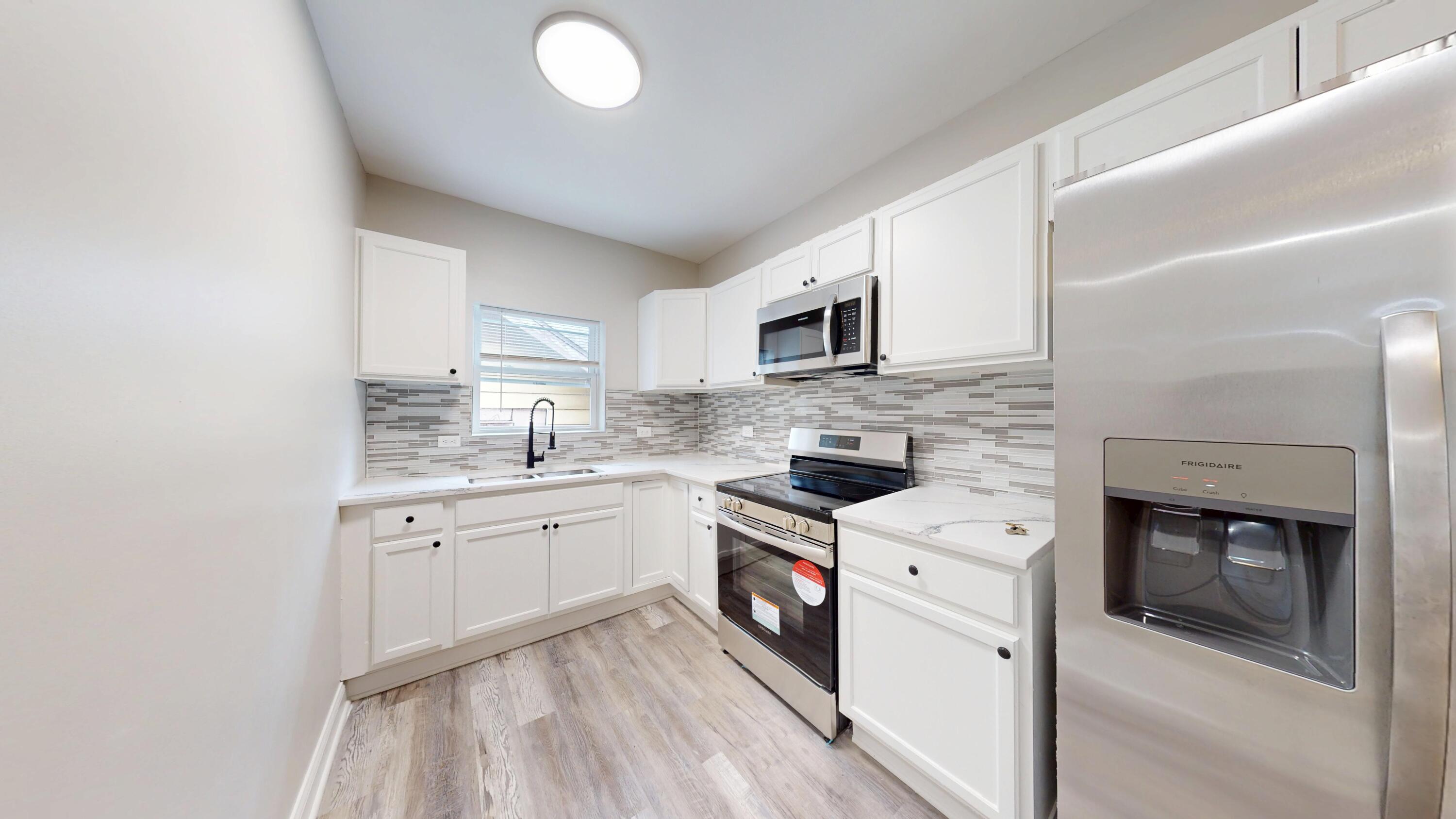 1379 Roosevelt Place Gary, IN 46404 - Photo 20 of 50 a kitchen with granite countertop a sink stove and microwave