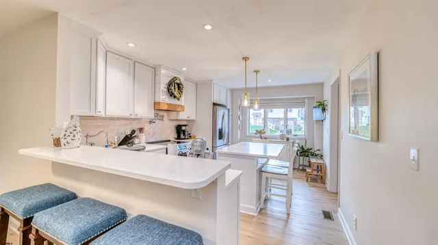 a kitchen with a dining table chairs cabinets and stove