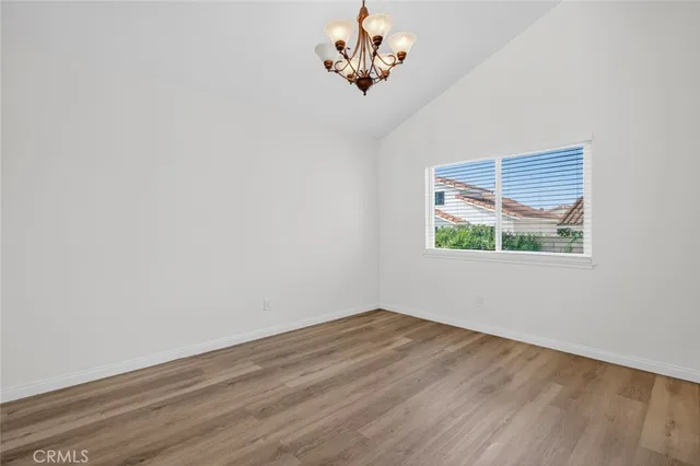 a view of a hallway with wooden floor and a chandelier fan