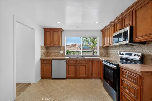 a kitchen with stainless steel appliances granite countertop a sink and stove top oven