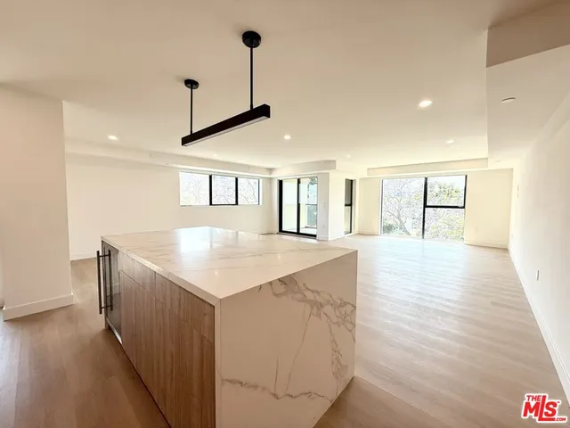 a kitchen with stainless steel appliances granite countertop a sink a microwave oven a refrigerator and white cabinets