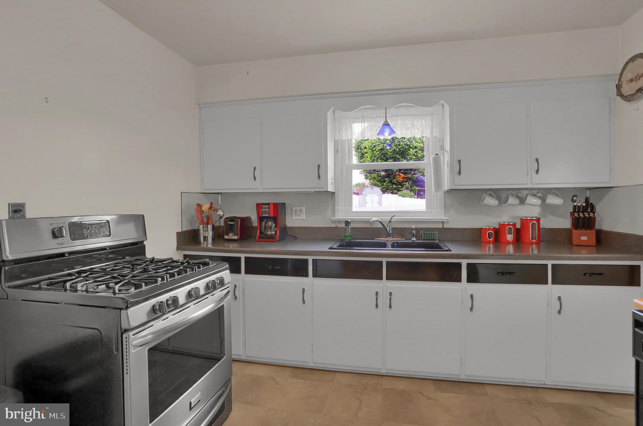 741 Gunnison Road York, PA 17404 - Photo 13 of 35 a kitchen with stainless steel appliances a stove a white cabinets and a window