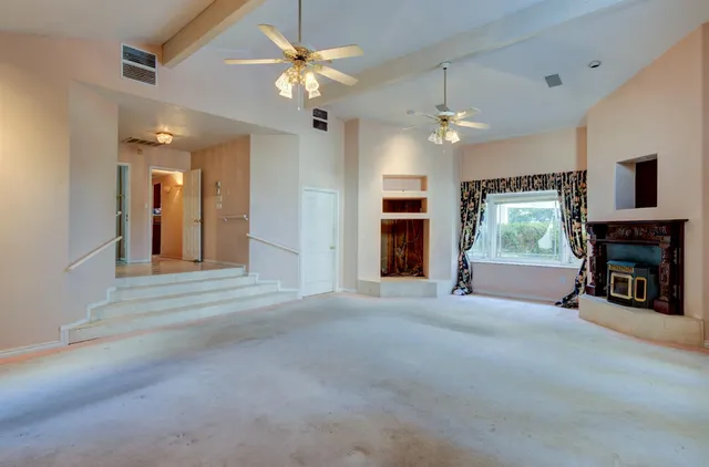 a view of a livingroom with a staircase and a ceiling fan