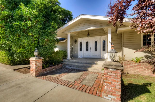 a view of an empty room with a fireplace and wooden floor