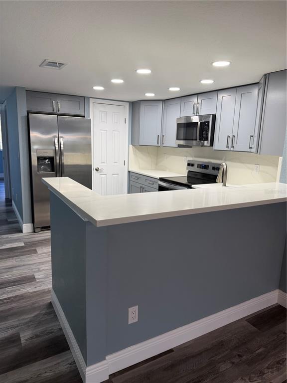 9794 Indian Key Trail, Unit 91 Seminole, FL 33776 - Photo 4 of 20 a large white kitchen with kitchen island a sink a stove a refrigerator and grey cabinets