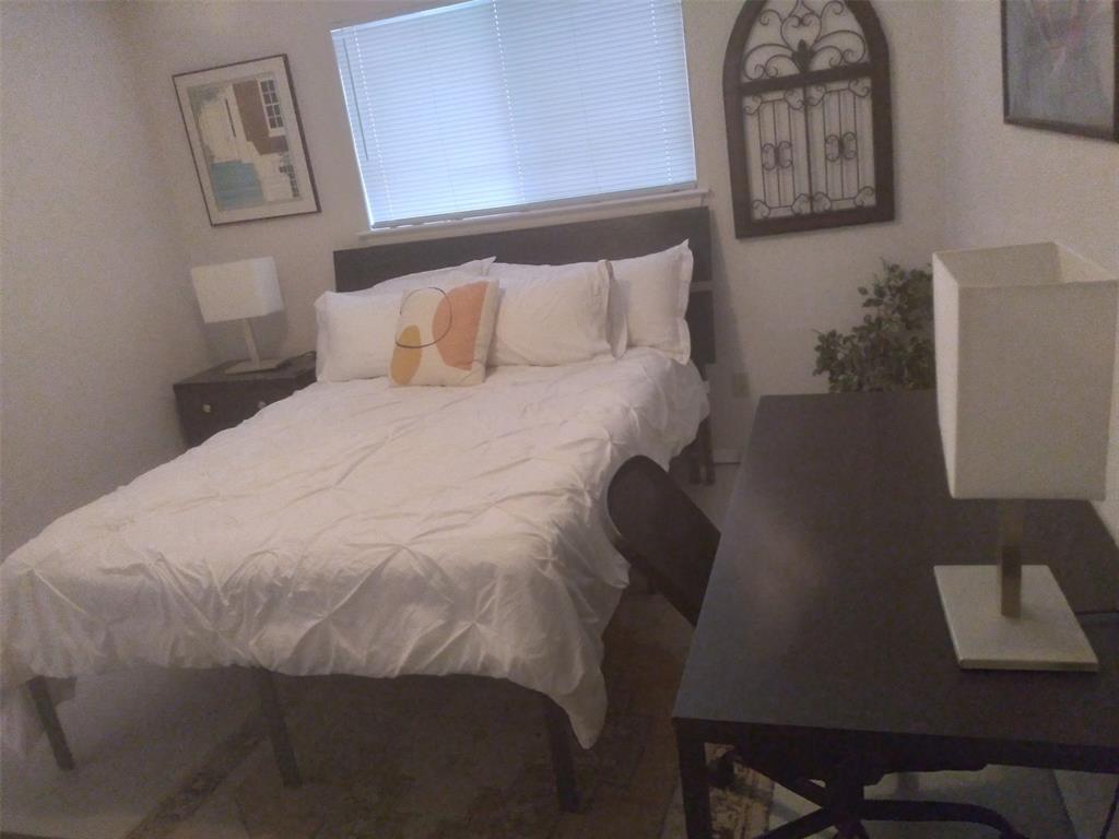 2714 McCart Avenue, Unit 2712 Fort Worth, TX 76110 - Photo 12 of 39 a bedroom with a bed and painting on the wall