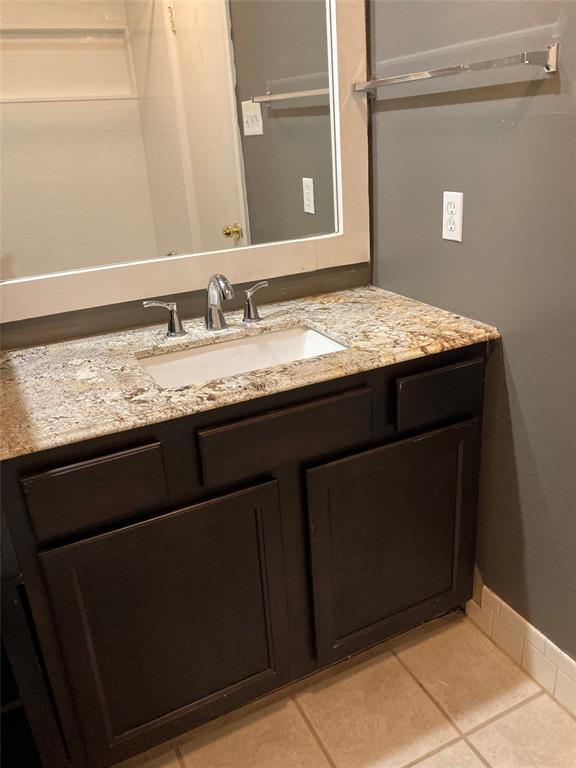 2714 McCart Avenue, Unit 2712 Fort Worth, TX 76110 - Photo 22 of 39 a bathroom with a granite countertop sink and a mirror