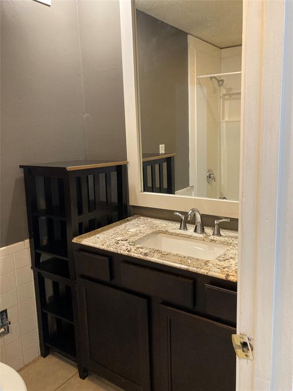 2714 McCart Avenue, Unit 2712 Fort Worth, TX 76110 - Photo 23 of 39 a bathroom with a granite countertop sink a mirror and a toilet