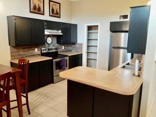 2714 McCart Avenue, Unit 2712 Fort Worth, TX 76110 - Photo 5 of 39 a kitchen with a sink refrigerator and cabinets