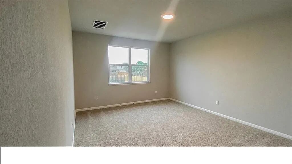 10612 Gonzales Ranger Pass Austin, TX 78754 - Photo 10 of 19 Soft carpeting pairs with neutral walls and a window overlooking the backyard.
