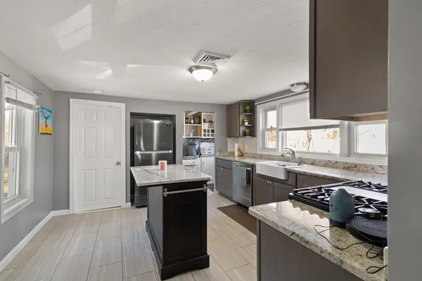 a kitchen with a sink a counter top space stainless steel appliances and cabinets