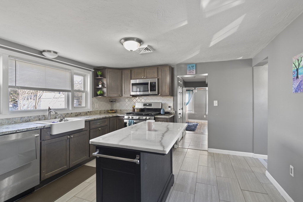 48 Wall Street Bridgewater, MA 02324 - Photo 15 of 29 a kitchen with a sink a counter top space stainless steel appliances and cabinets