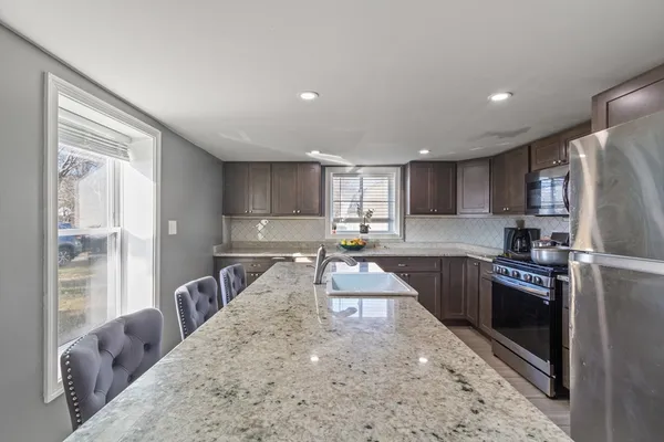 a kitchen with a refrigerator sink and wooden cabinets