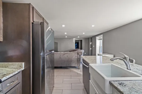 a living room with stainless steel appliances furniture and a flat screen tv