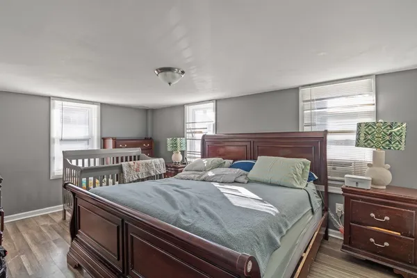 a bedroom with a bed and wooden floor