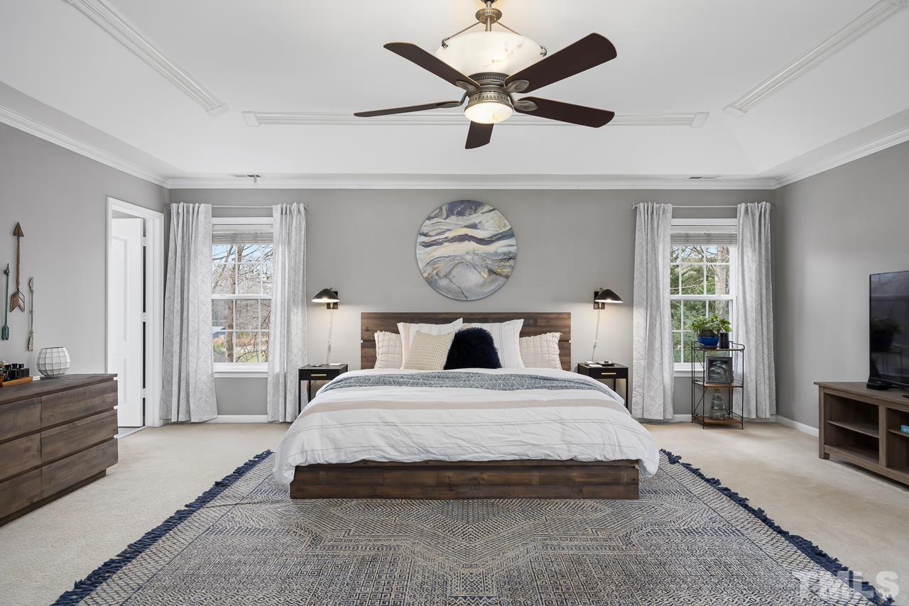 2836 Roundleaf Court Raleigh, NC 27604 - Photo 20 of 39 a bedroom with a large bed and a chandelier