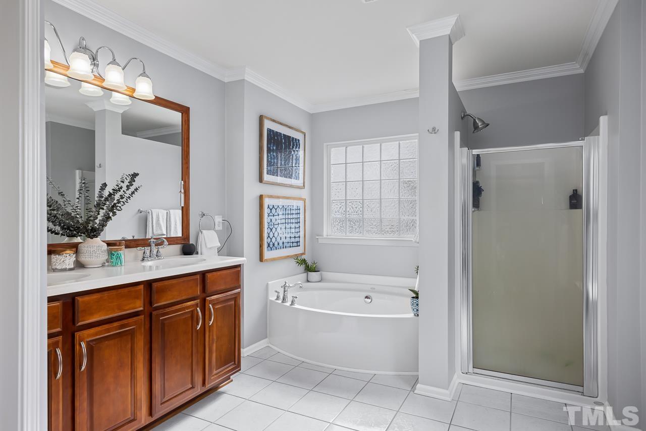 2836 Roundleaf Court Raleigh, NC 27604 - Photo 23 of 39 a bathroom with a tub sink shower and mirror