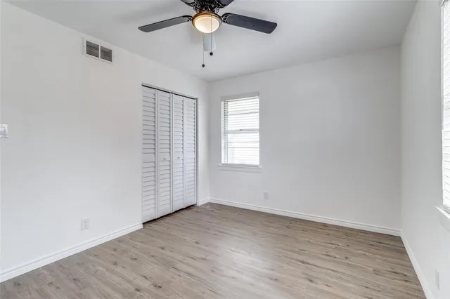 an empty room with a window and a fan