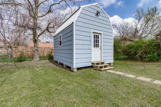 a view of a yard in front of a house with a large tree