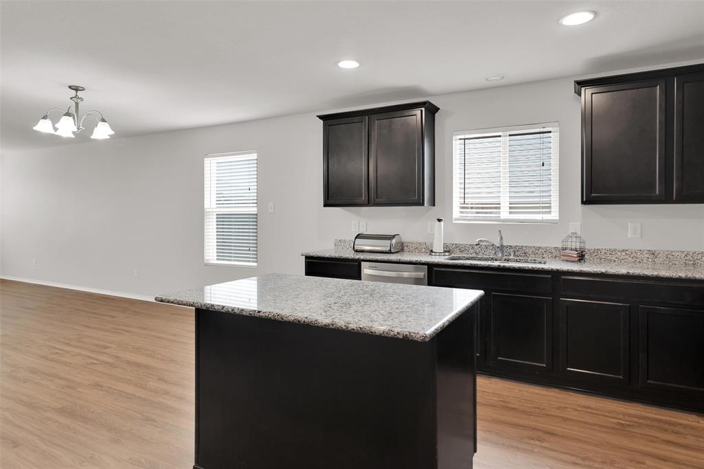 3011 Hickory Ridge Melissa, TX 75454 - Photo 8 of 30 Kitchen featuring an island with stone countertops, dark wood cabinetry, stainless steel sink, and recessed lighting