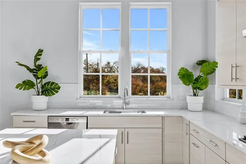 a kitchen with a granite counter top a potted plant on the counter and a window