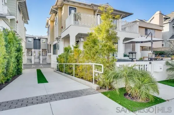 a view of a white building with a yard