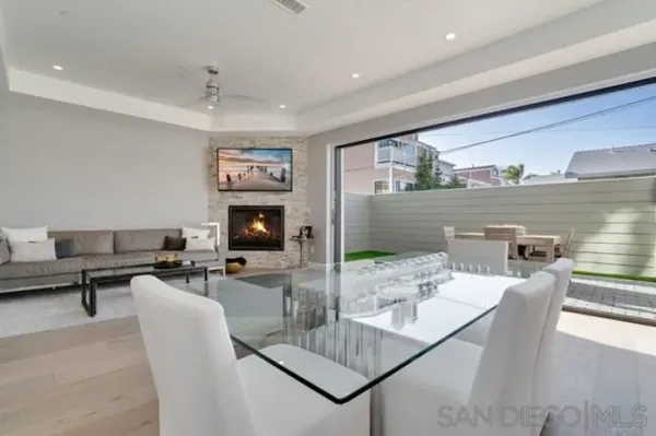 a kitchen with stainless steel appliances granite countertop a refrigerator a stove a kitchen island a dining table and chairs