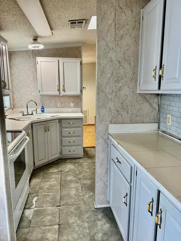 a spacious bathroom with a granite countertop sink a toilet and mirror