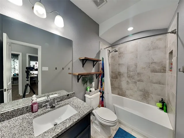 a bathroom with a granite countertop sink toilet and shower