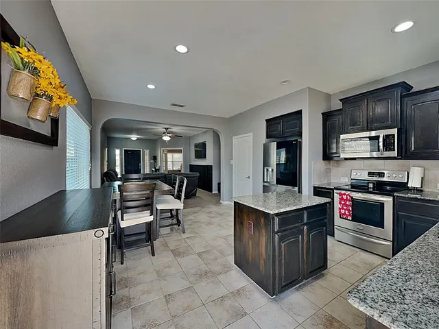 a kitchen with a stove a refrigerator and a dining table
